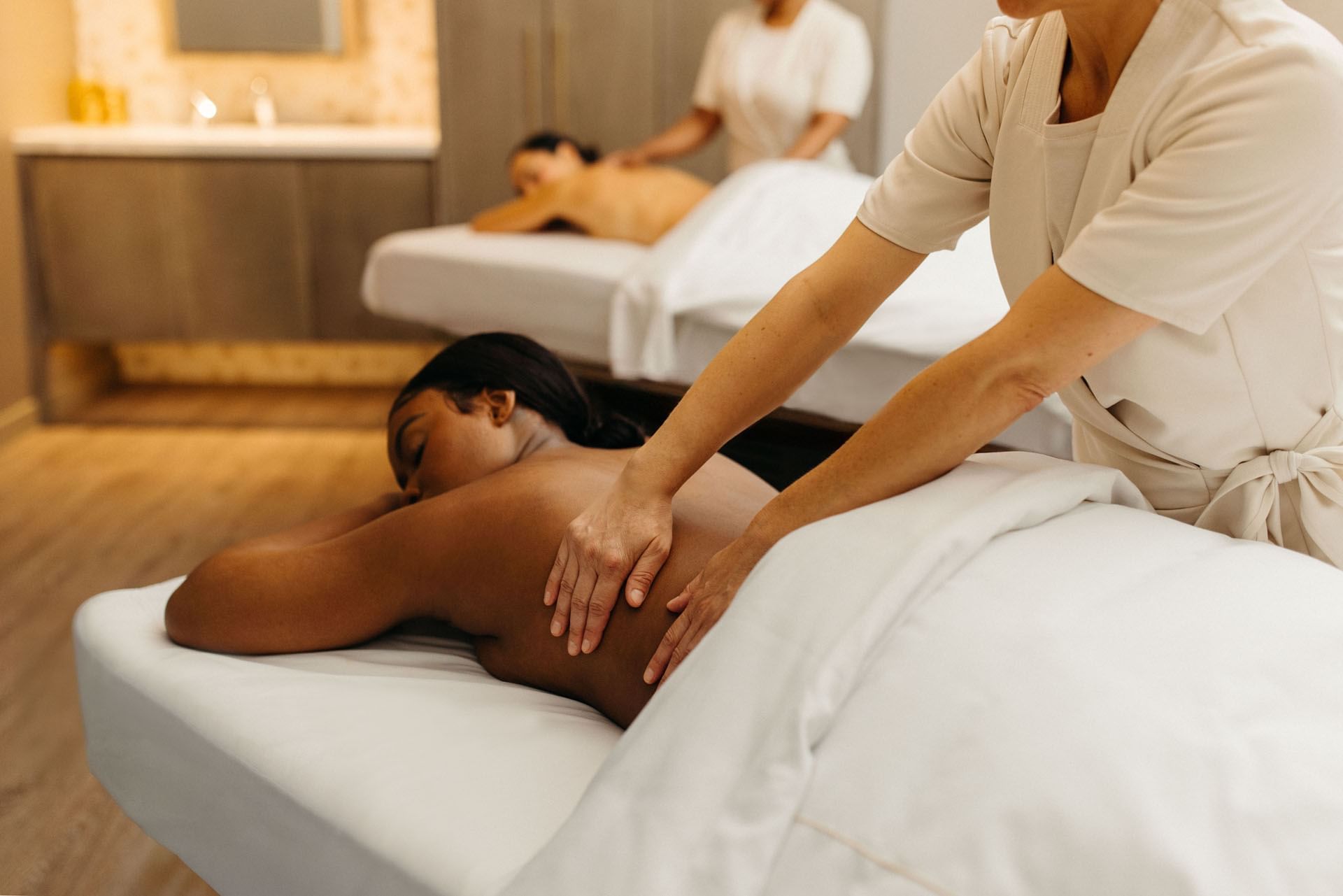 Women receiving a back massage in Guerlain spa at Hotel X Toronto