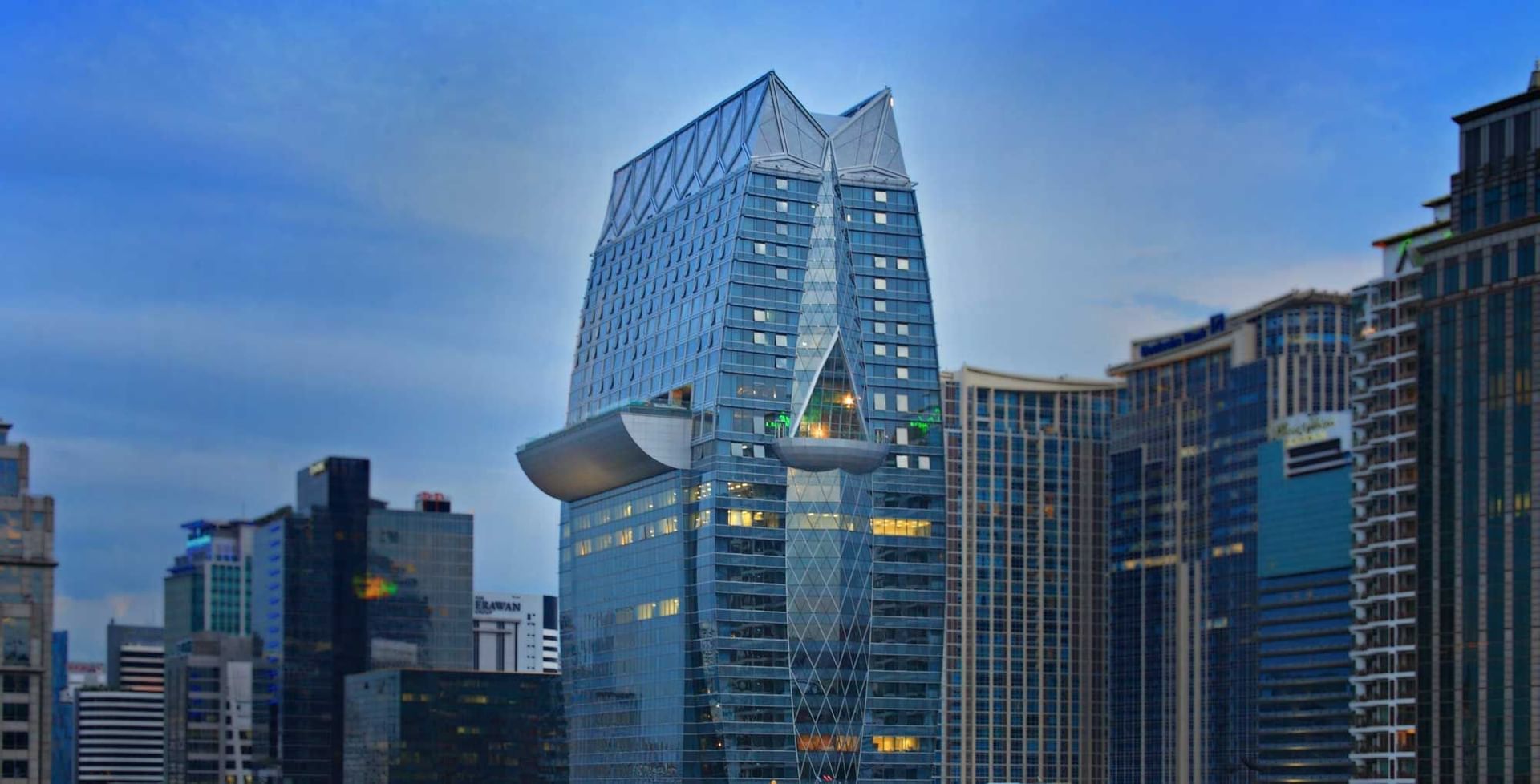 A distant exterior view of Okura Prestige Bangkok & buildings