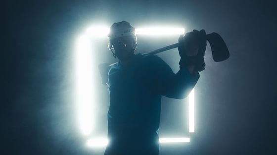Hockey player by a glowing frame in a smoky room near Paramount Hotel Seattle
