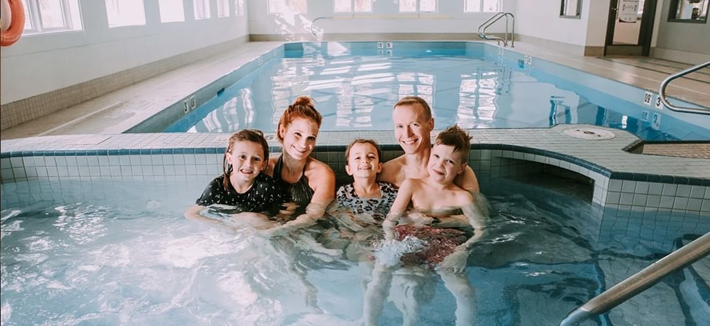 A family enjoys the hot tub at their hotel in Canmore after remembering to pack their swimsuits.