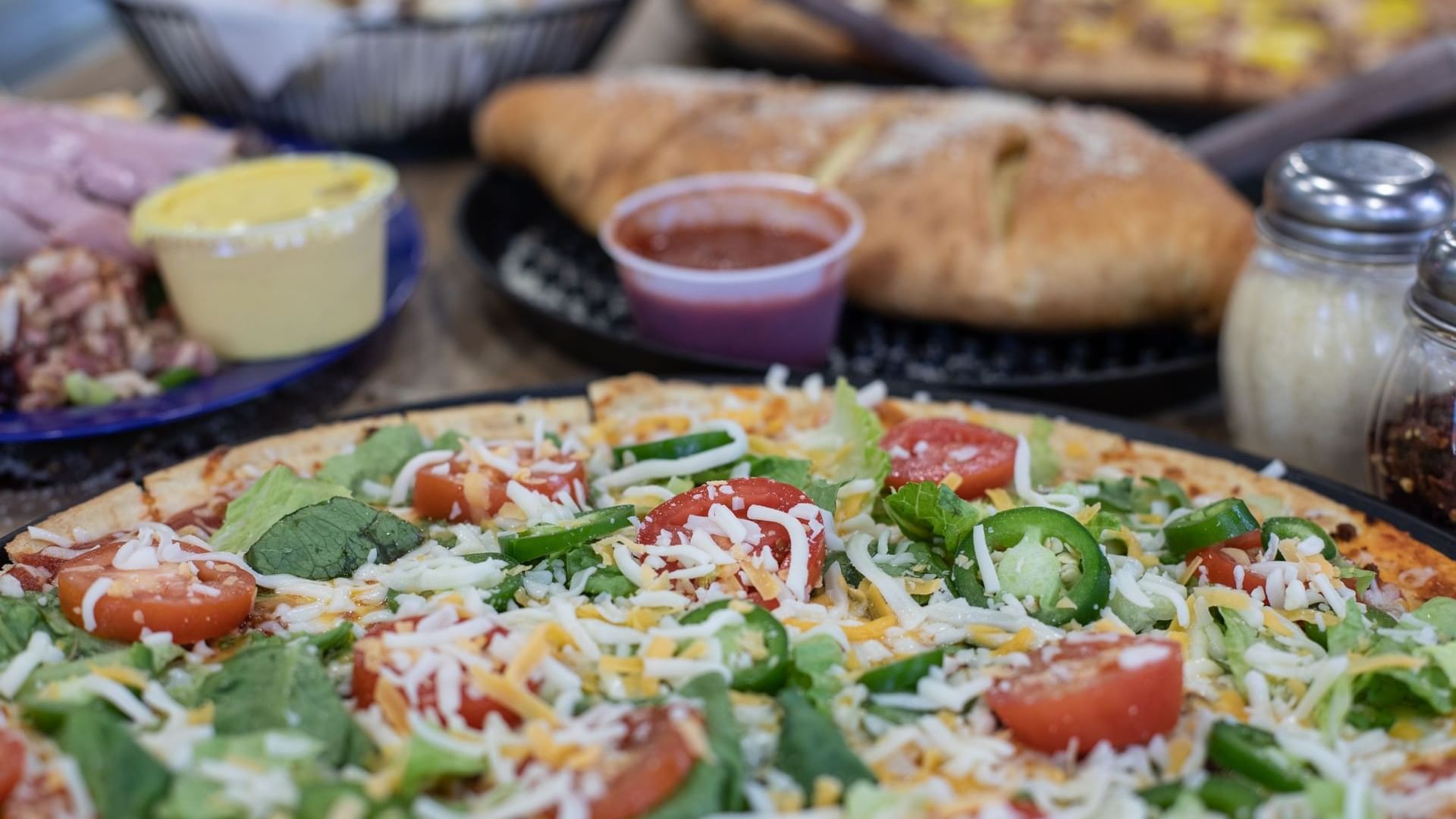 Close-up of Pizza served with bread in Bruno’s Pizza at Watersound Inn