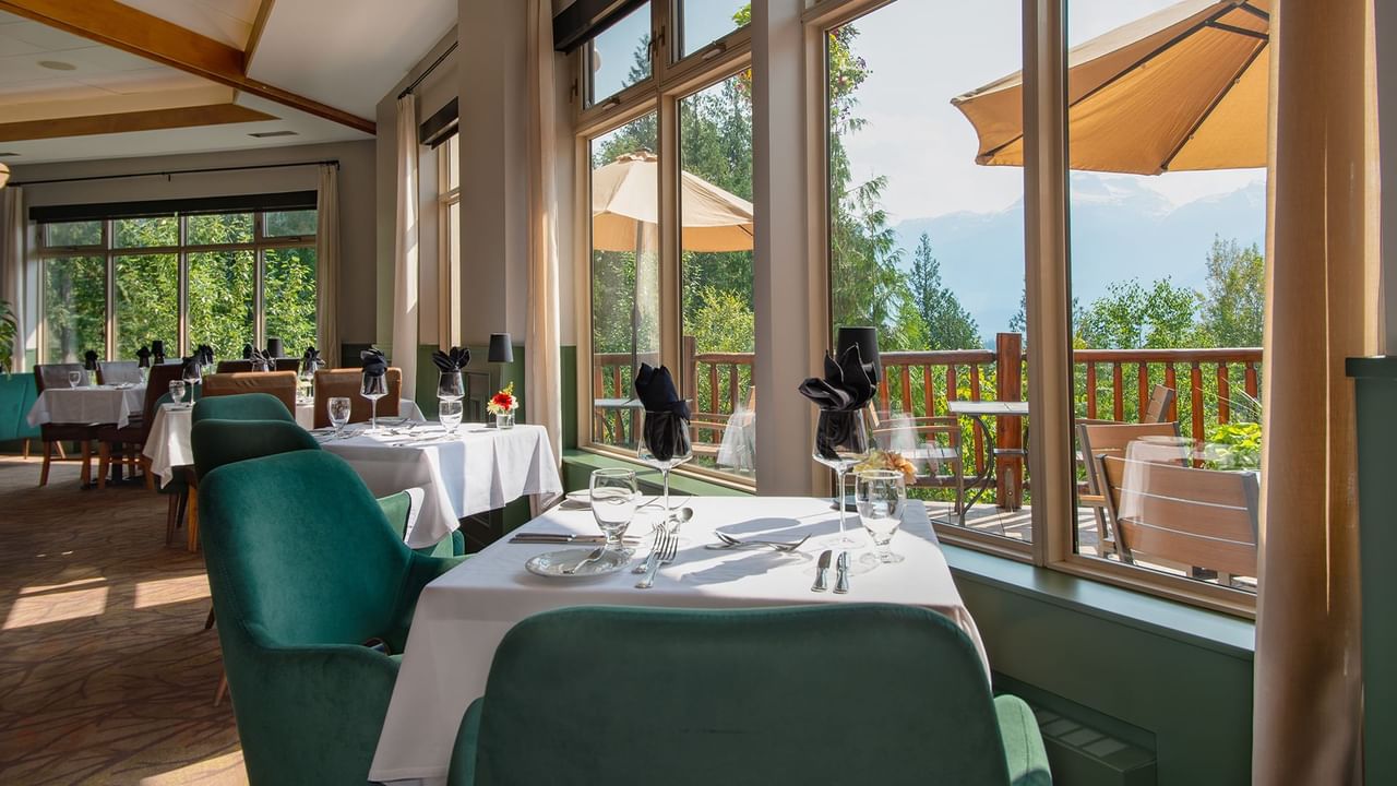 Hotel restaurant with dining table, chairs and patio