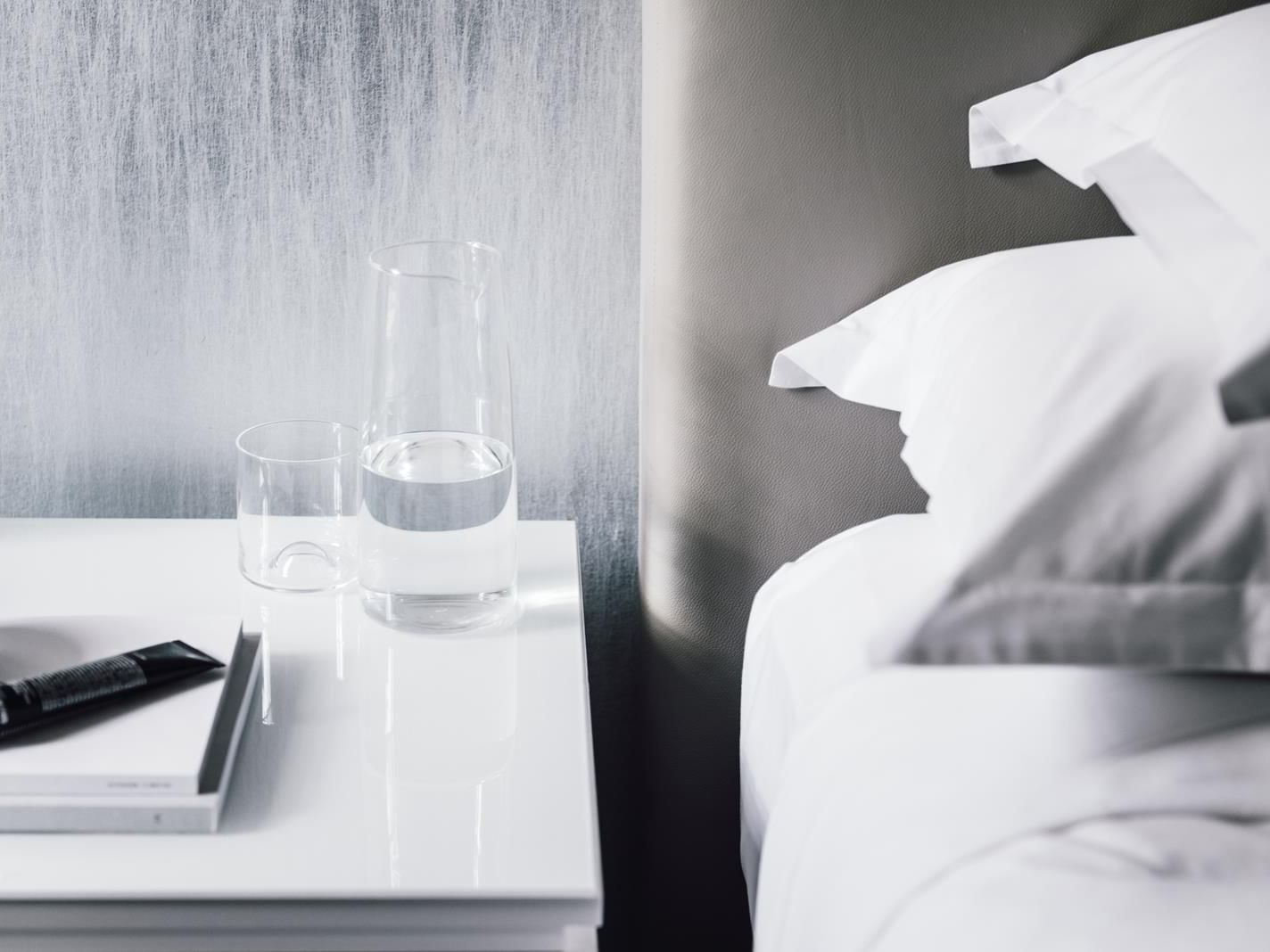 Glass of water by the bed in a Room at The Como Hotel Melbourne