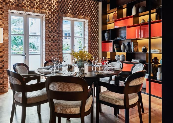 Square One interior with wooden floors, chairs, and shelves showcasing a variety of drinks at Park Hyatt Saigon