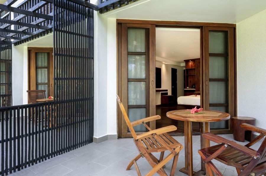 Folding wooden chairs by a small round table on a balcony in Garden View Rooms at Warwick Fiji Resort and Spa