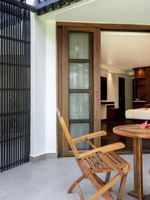 Wooden chairs and table with flowers on a balcony with garden view at Warwick Fiji Resort and Spa in Korolevu.