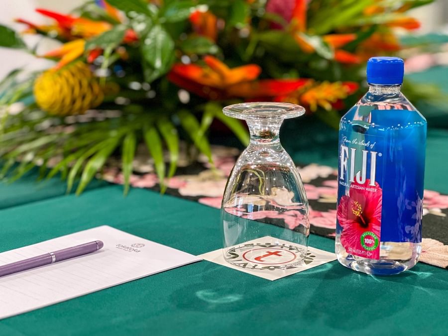 Water bottle and a glass by a notepad on a green meeting table at TokaToka Resort Nadi Fiji
