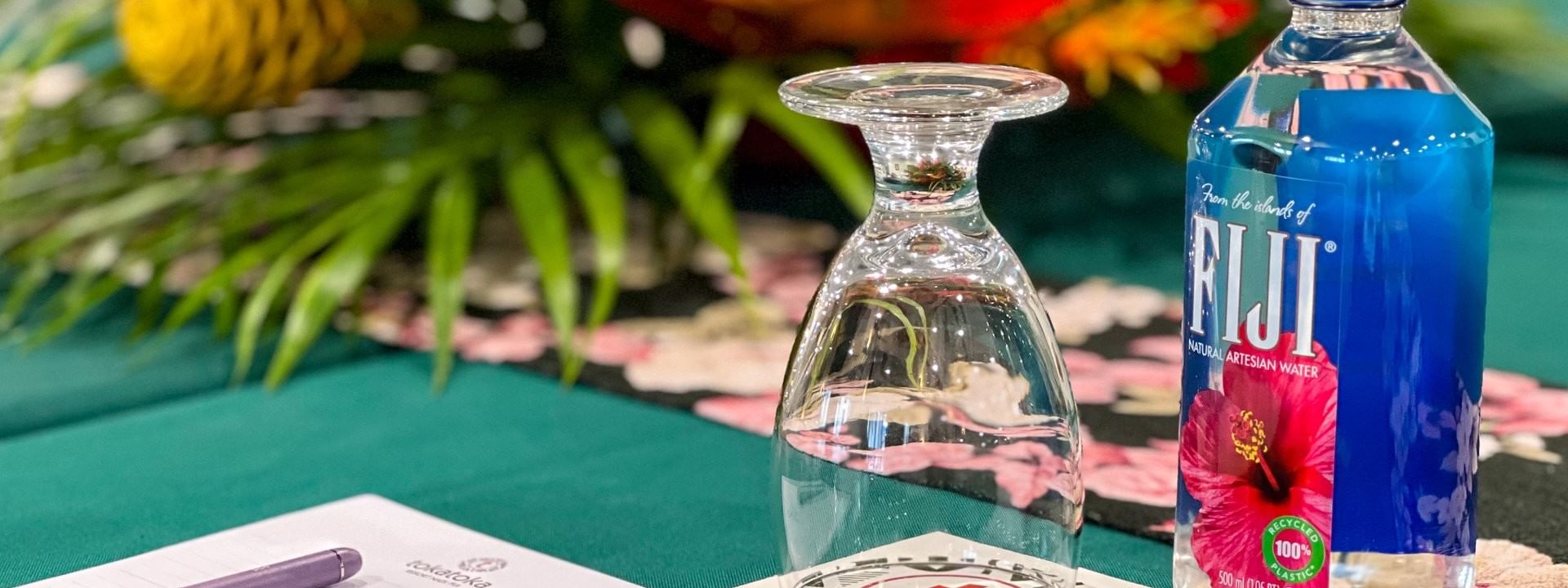 Glassware, water bottle, and notepad on green table at Talei Meeting Room in Tokatoka Resort Nadi