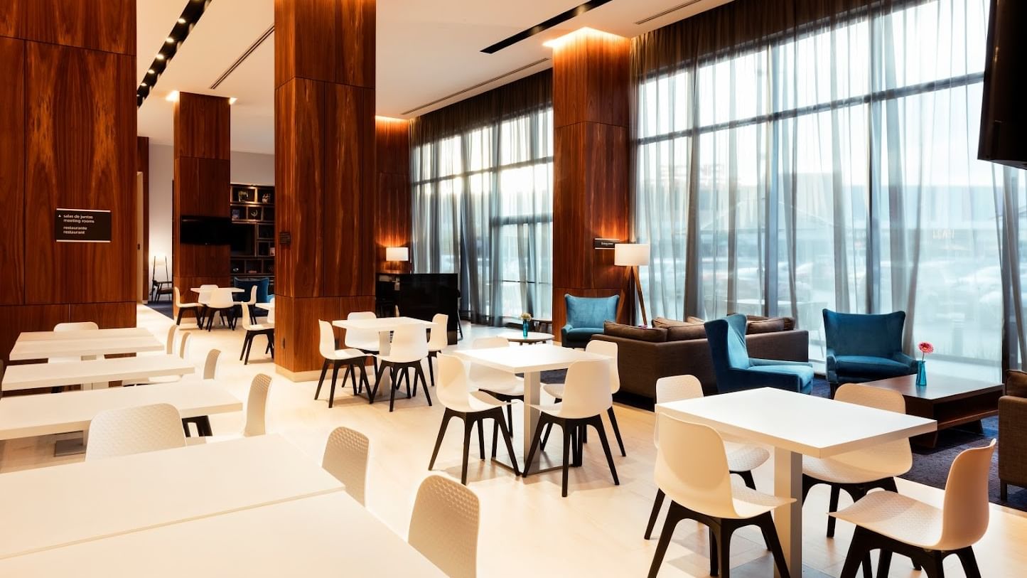 Dining area at Fiesta Inn Express Cancún Cumbres featuring tables near a lounge by the window, best restaurants in Cancun