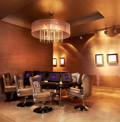 Swivel chairs at computer stations under a crystal drum chandelier in the business center at Megapolis Hotel Panama