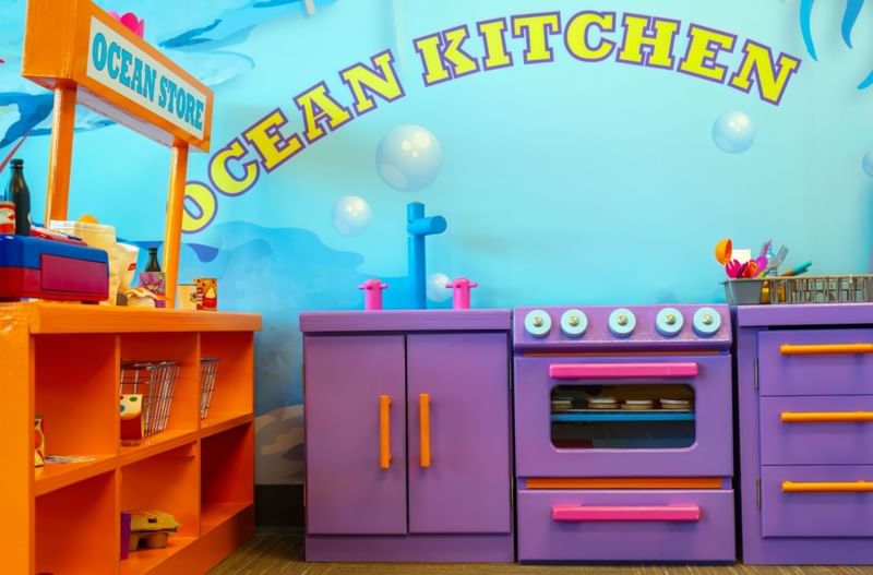 Colorful children's play kitchen area at The Diplomat Resort, labeled Ocean Kitchen and Ocean Store