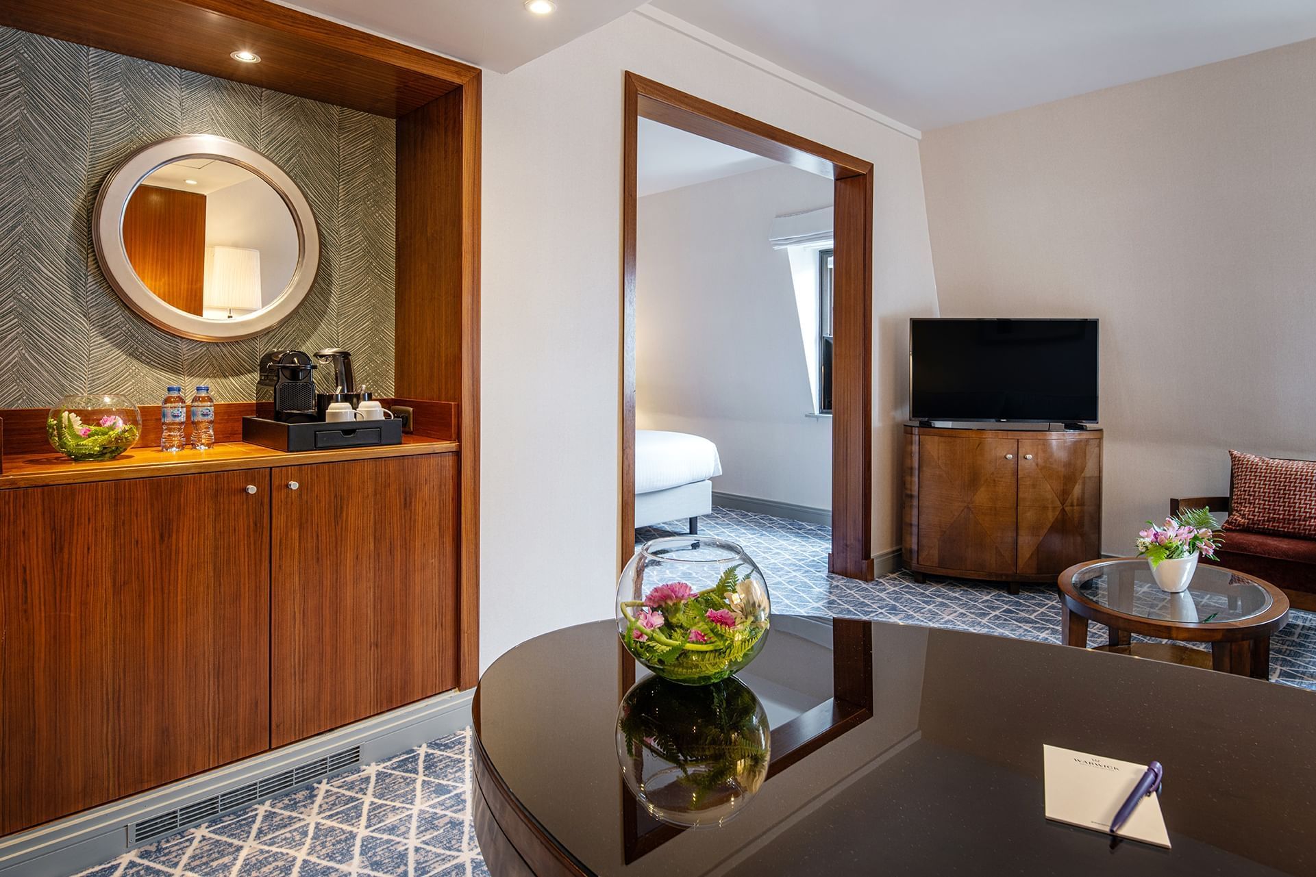 Living area with table and wooden cabinet in Junior Suite at Warwick Brussels