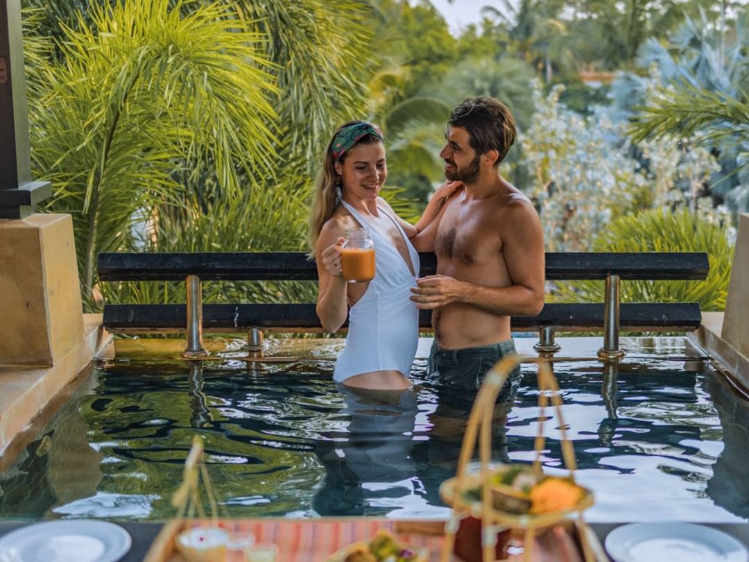 Couple enjoying a Thai Afternoon Tea Set while relaxing in a private rooftop plunge pool at the Penthouse Villa of a 5-star resort in Phuket.