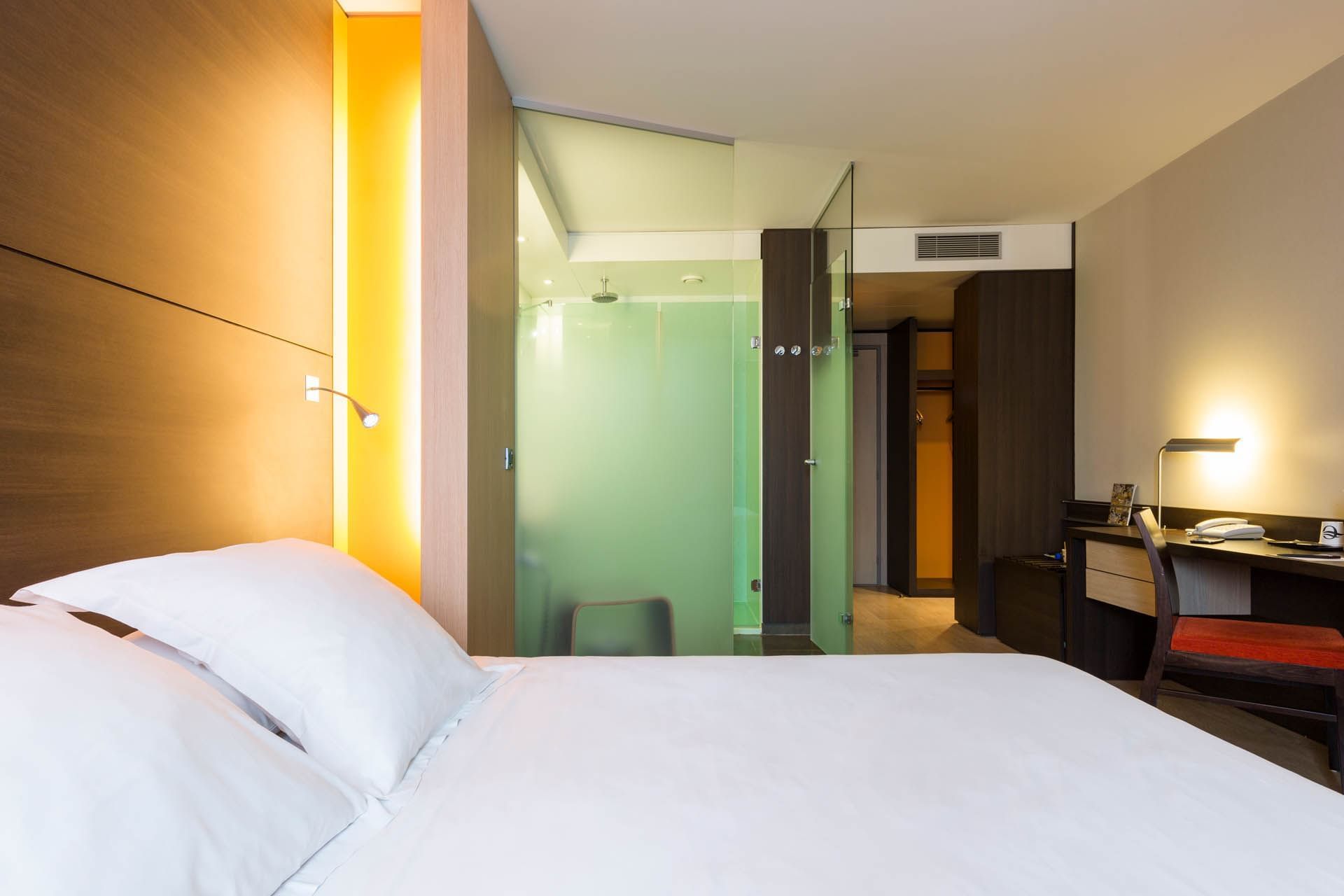 King bed & desk in a room at Oceania Nantes Aéroport