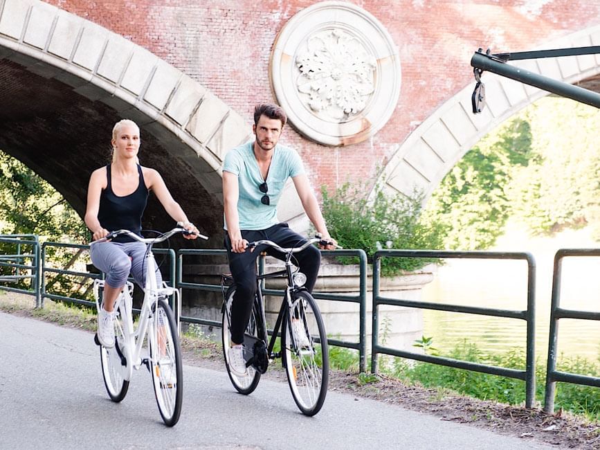 Couple riding bicycles near Duparc Contemporary Suites