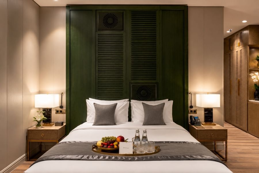 Fruit tray on bed between lamps in Executive Suite at Naviti by Warwick Jeddah, offering a comfortable boutique stay