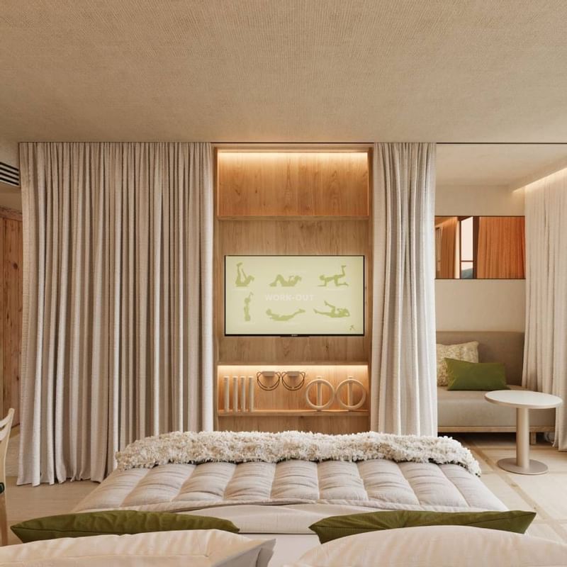 Comfy bed, TV & lounge area at Falkensteiner Hotels