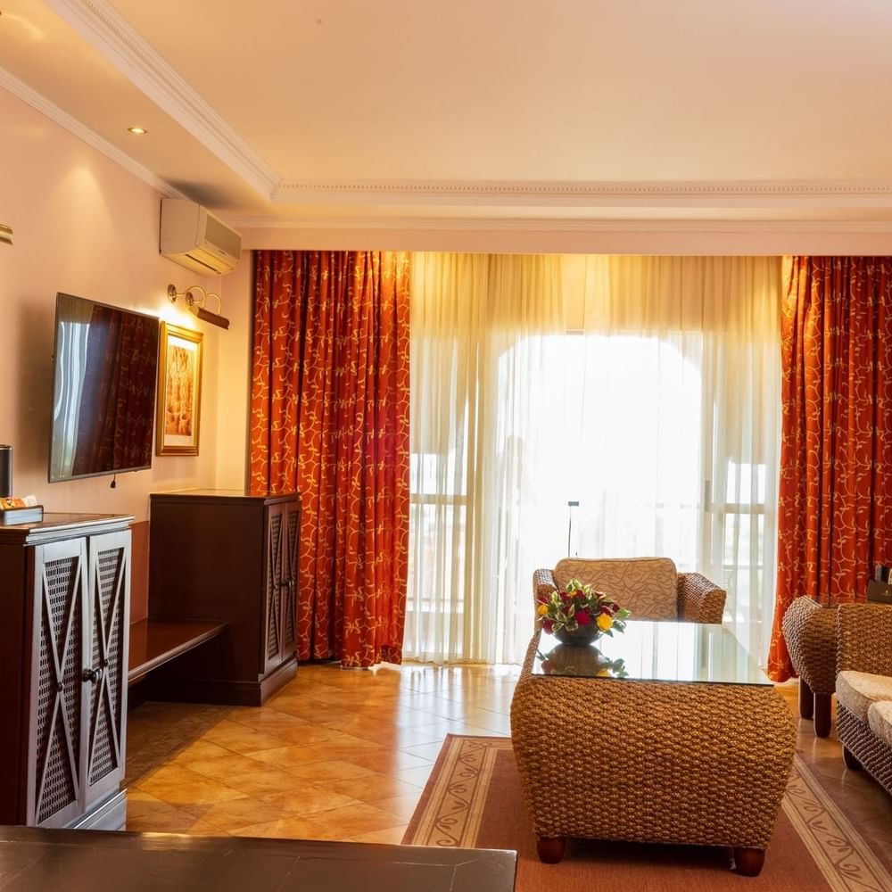 Executive Suite living area with couch, coffee table, and TV at Lake Victoria Serena Golf Resort & Spa in Kampala.