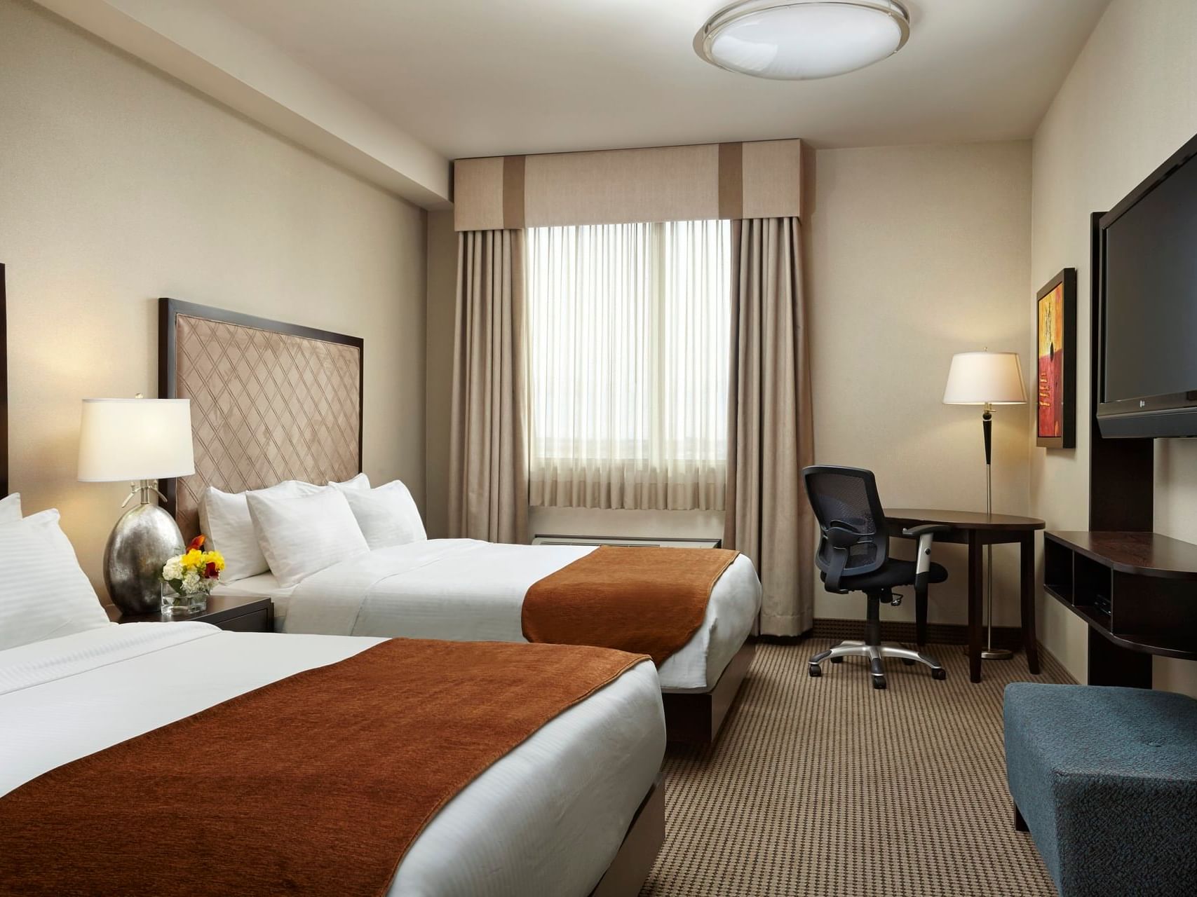 Two beds, work desk & TV in Diamond Two Queen Suite at Acclaim Hotel Calgary