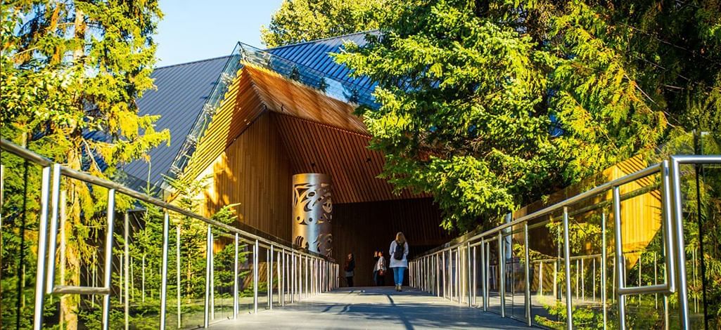 Visitors approach the striking wooden entrance of the Audain Art Museum, nestled in Whistler's forest.