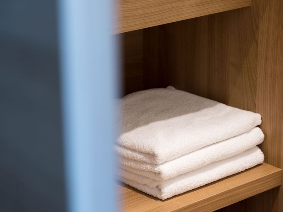 Stacked white towels on the shelf at Hotel Neptune