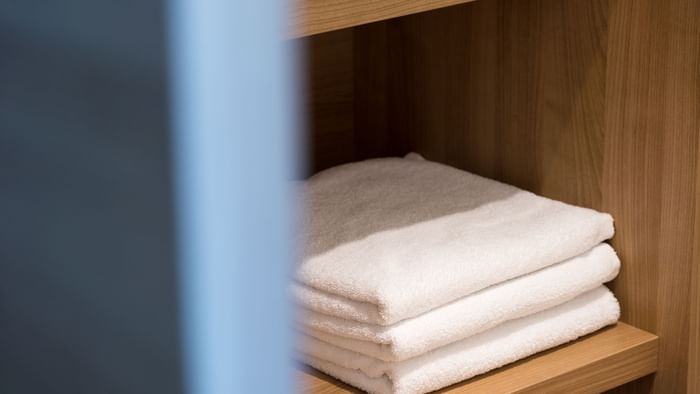 Stacked white towels on the shelf at Hotel Neptune