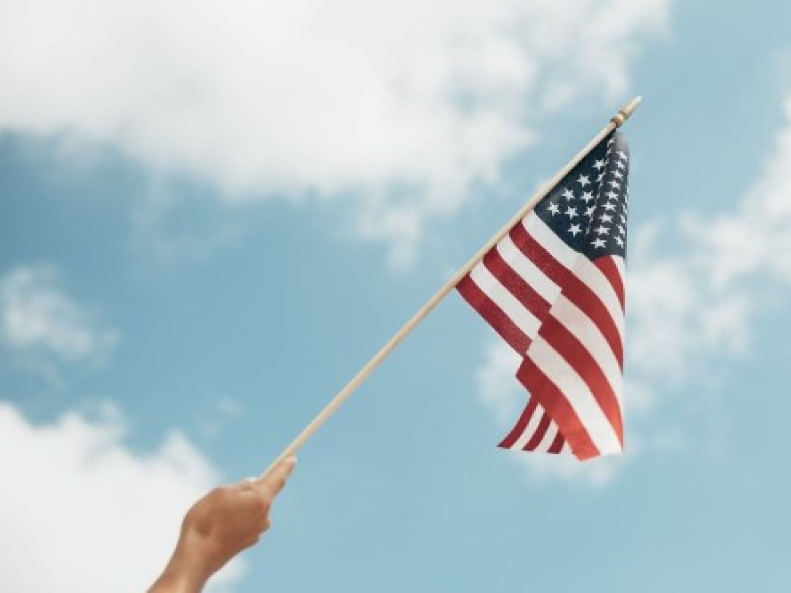 A person holding the American flag at La Galerie Hotel