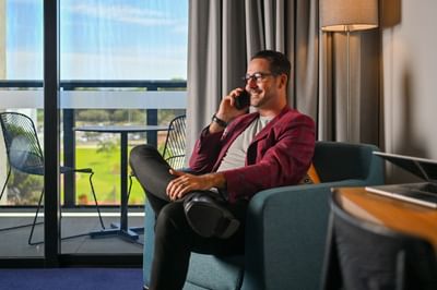 Man on a phone call while lounging at Nesuto Curtin Perth Hotel