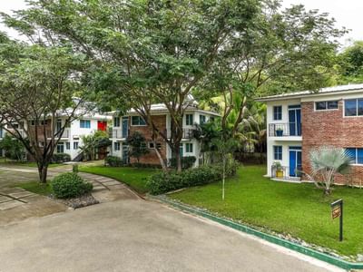 Hotel exterior of Cha Cha Hotel with lush green trees