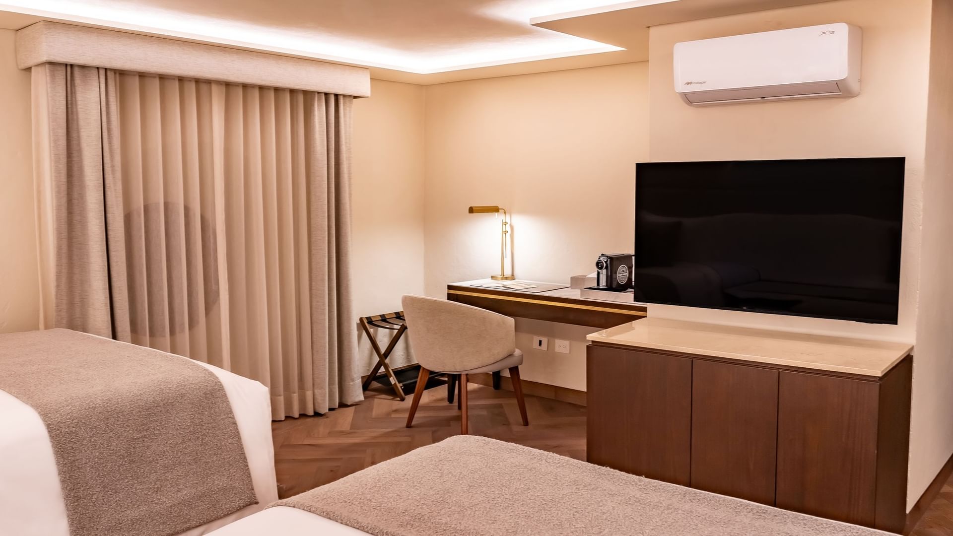 Two queen beds, desk, chair, flat-screen TV, and air conditioner in 2 Queen Deluxe room at Quinta Real Puebla in Heroica Puebla de Zaragoza.