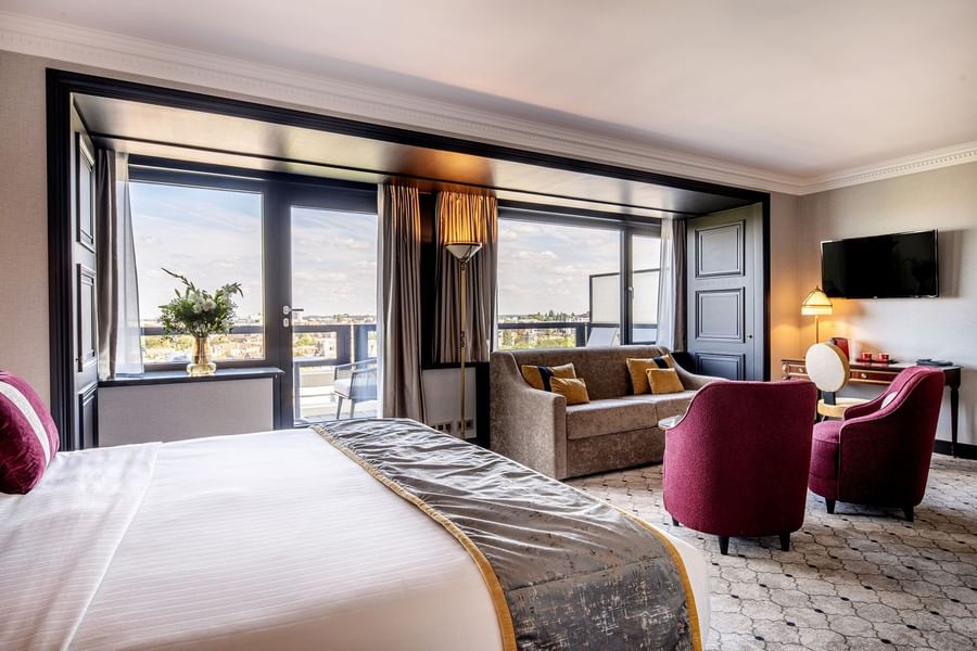 Bed facing plush armchairs and sofa by a terrace window in Junior Suite with terrace at Hotel Barsey by Warwick