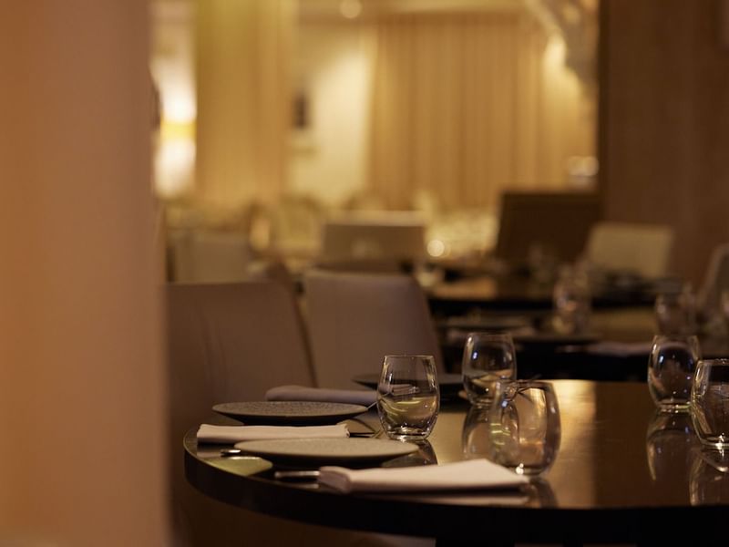 Dining table set with plates, silverware & glasses in Modo Mio restaurant at Crown Promenade Perth