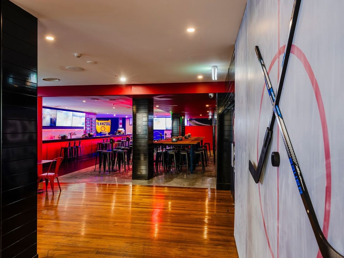 Seating area featuring wall decor with hockey sticks in KG Sport Bar at Mercure Brisbane King George Square