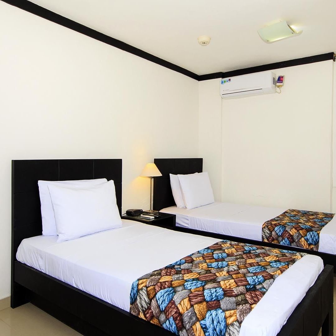 Twin beds in a room at GIO Hotel Santa Marta Tama