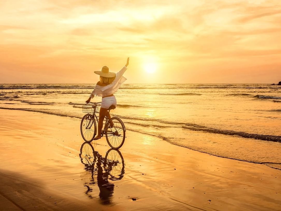 Lady riding a bicycle on the beach near Las Olas Beach Resort featuring Panama day tours