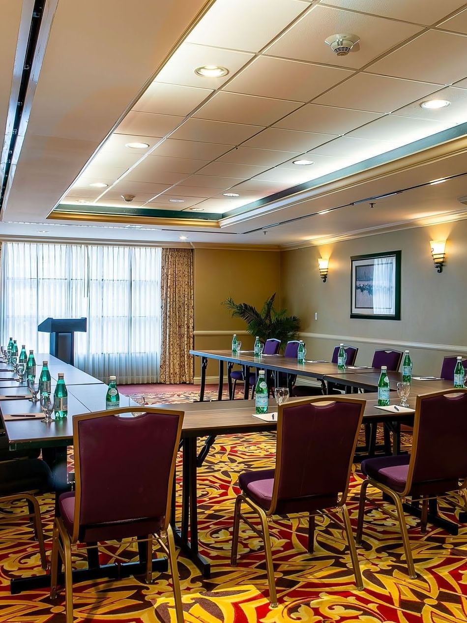 Capitol I, II or III at Warwick Denver featuring a U-shaped table by purple chairs under soft wall sconces