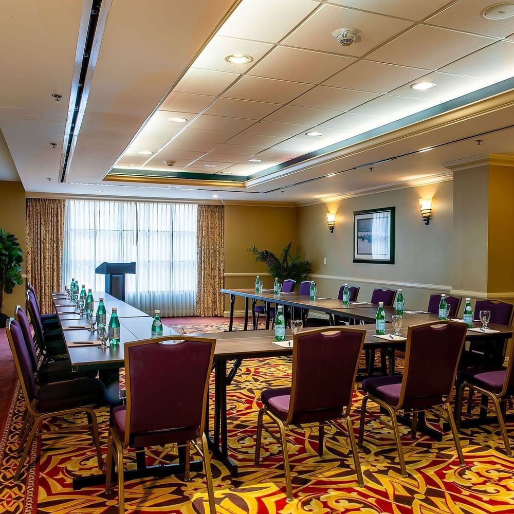 Capitol I, II or III at Warwick Denver featuring a U-shaped table by purple chairs under soft wall sconces