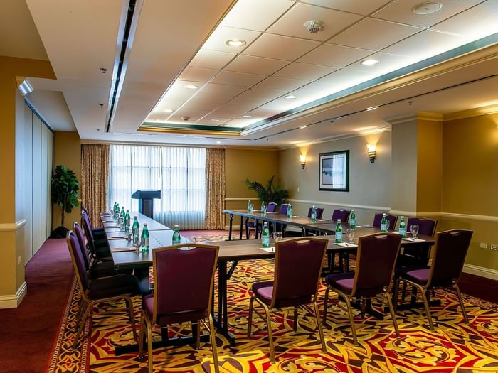 Capitol I, II or III at Warwick Denver featuring a U-shaped table by purple chairs under soft wall sconces