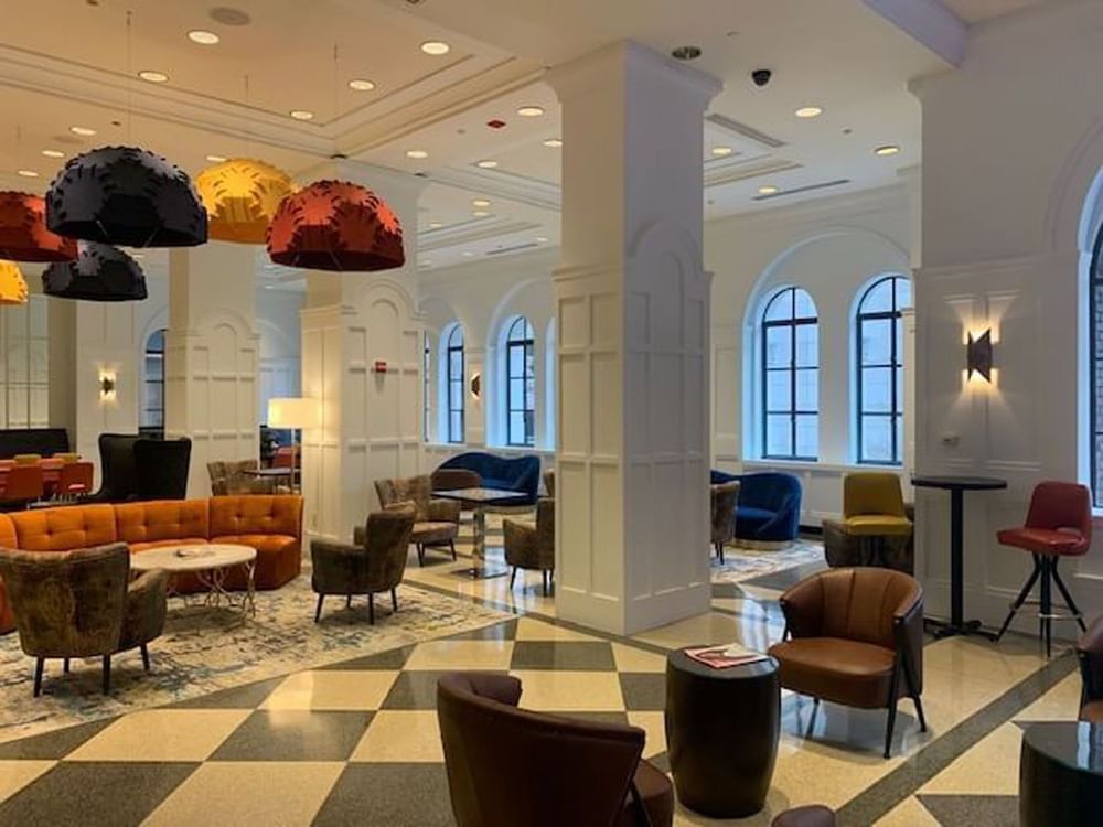 Stylish lobby lounge featuring orange sofas, armchairs, and colorful dome lights at Warwick Allerton Chicago