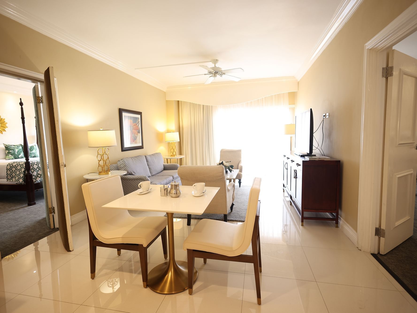 Spacious living room with a cozy couch, a dining table & a TV in Penthouse Two Bedroom Suite at Courtleigh Hotel and Suites