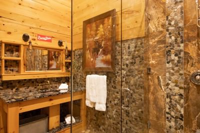 Shower cubicle, bathroom vanity with wooden shelves in King Executive Log Cabin at Retro Suites Hotel