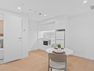 Modern apartment interior with white furniture and wooden floors at UniLodge Brisbane City.