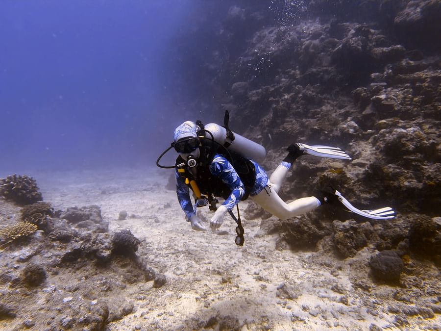 Scuba diver exploring coral reef underwater at Tambua Sands Beach Resort in Sigatoka