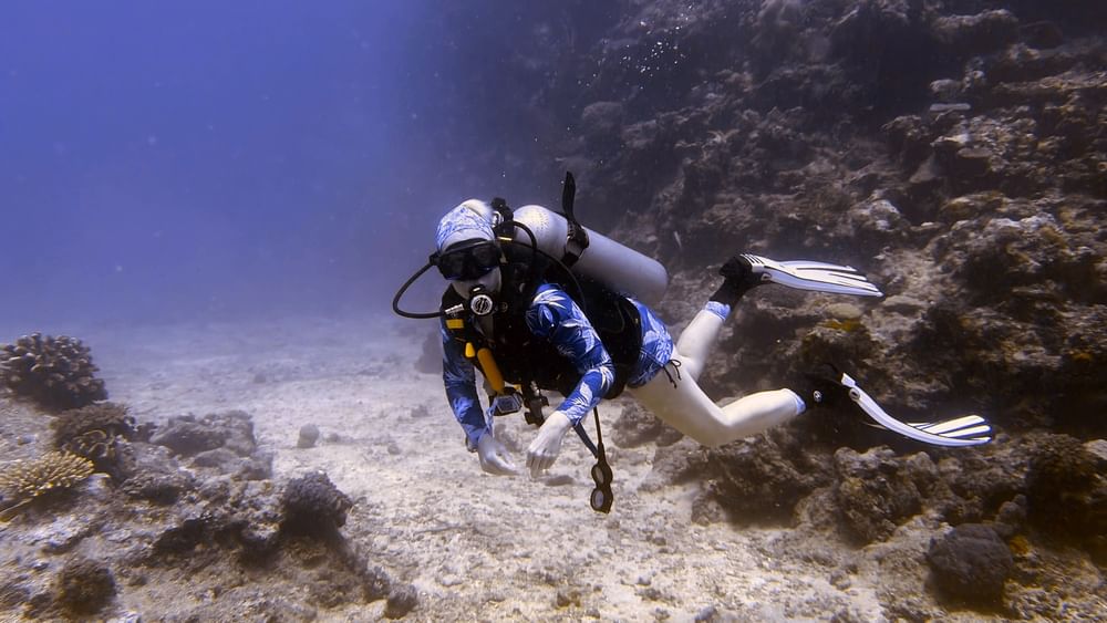 Diver exploring vibrant coral reef underwater, showcasing the Dive Centre at The Naviti Resort in Korolevu.