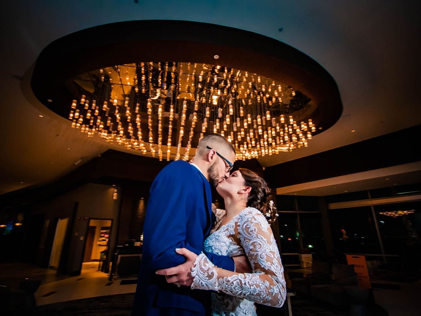 Bride and groom kissing in the lobby of Renaissance Patriot Place