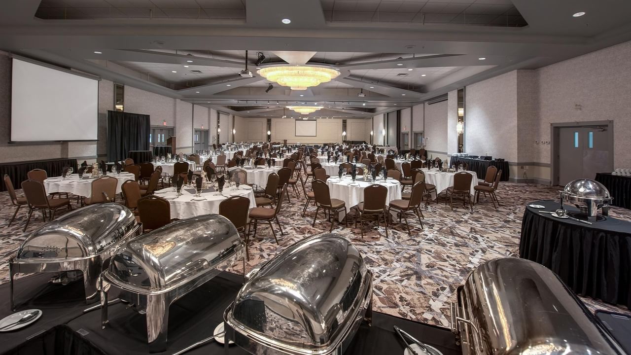 Banquet hall with set tables and chairs.