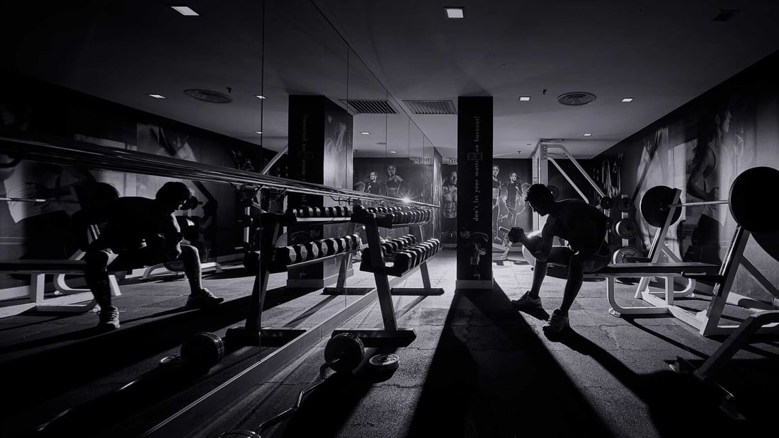 A person exercising with dark lights in the Fitness Centre at Sunway Putra Hotel