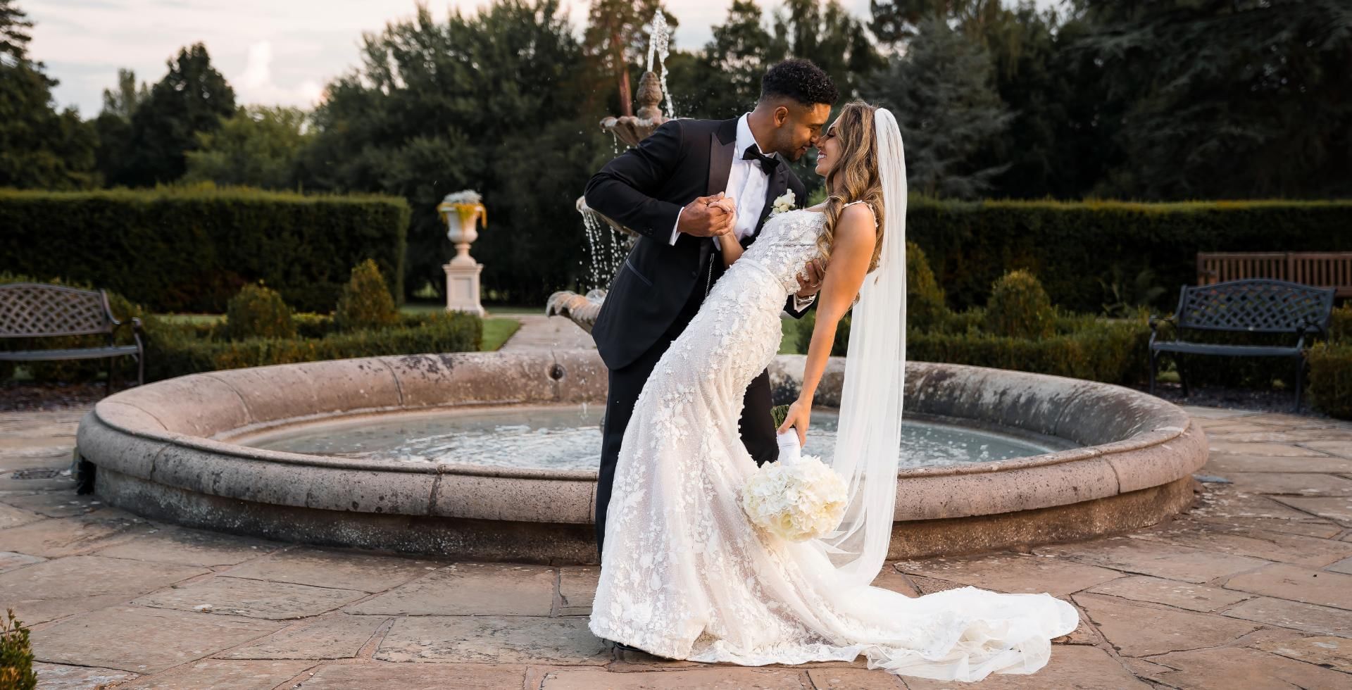bride and groom by fountain at easthampstead park in berkshire
