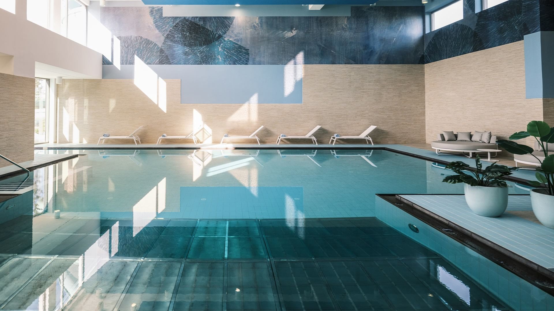 Veliki bazen s ležaljkama i loncima s biljkama u luksuznom spa centru.