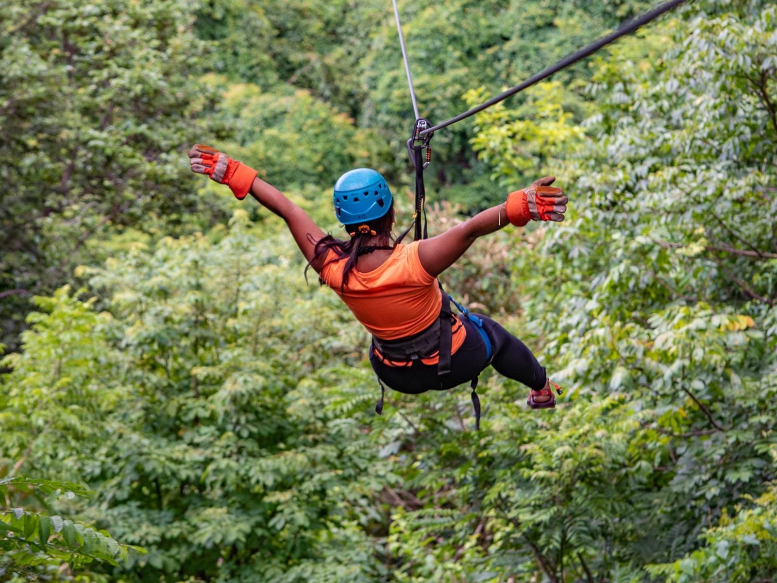 A lady ziplining through the forest near Punta Islita Hotel